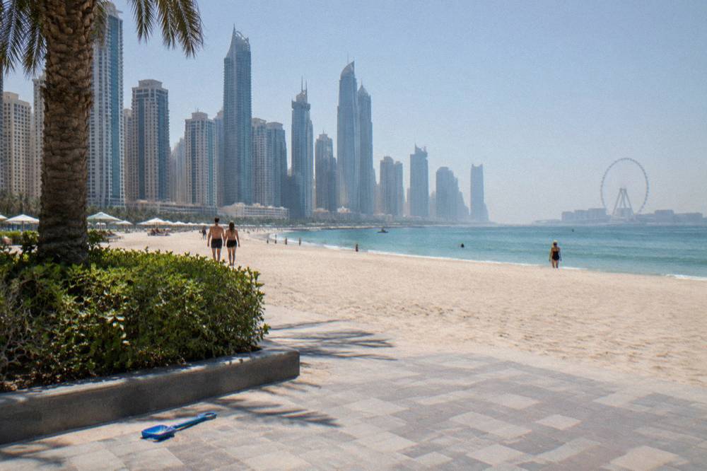 Beachfront promenade beside open sand and calm sea