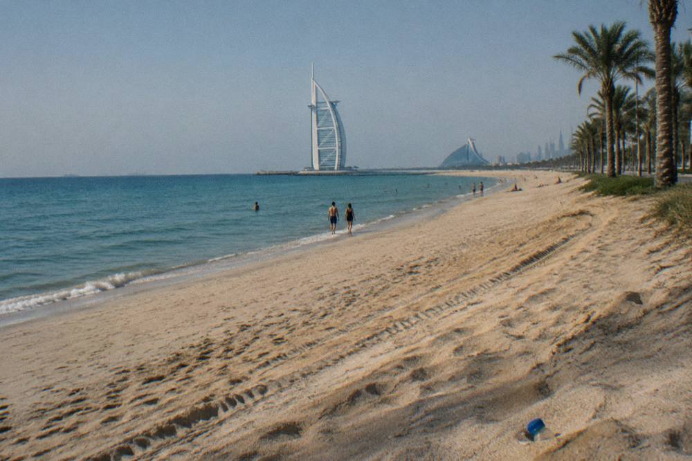 Wide sandy beach with calm water and clear sky along the Dubai coast