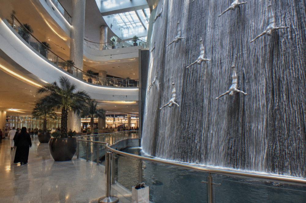 A waterfall feature inside a large shopping mall atrium