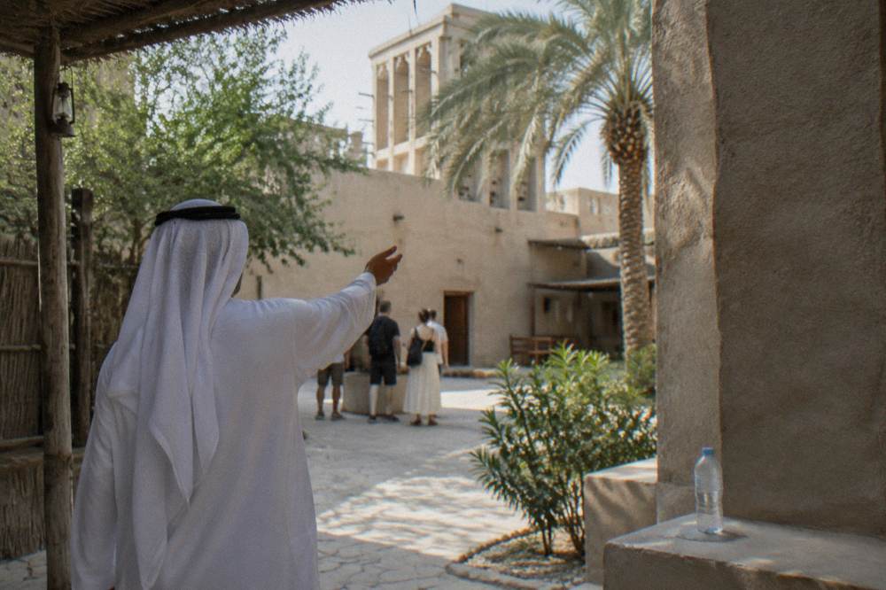 A walking tour group exploring the historic Al Fahidi district with a guide