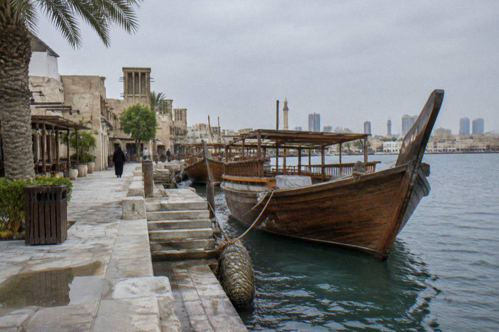 Waterfront promenade with moored wooden boats and heritage facades at Al Seef