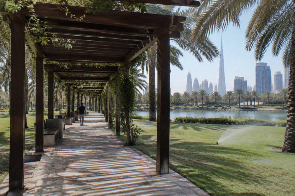 Shaded walkway and lawns inside a public park in Dubai