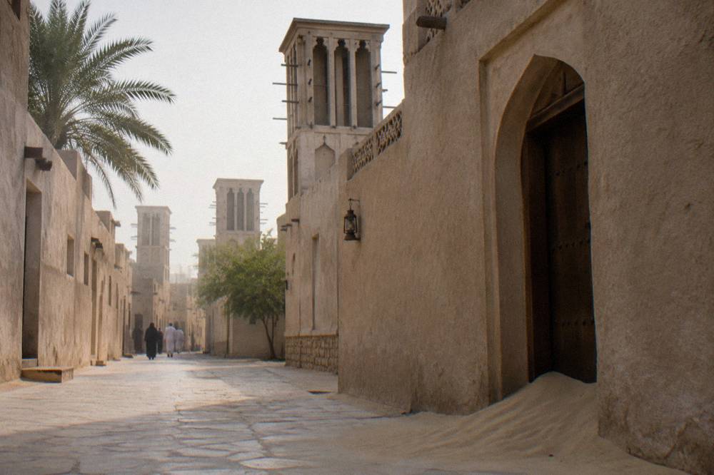 Narrow lane with sand coloured walls and wind towers in the Al Fahidi Historical Neighbourhood