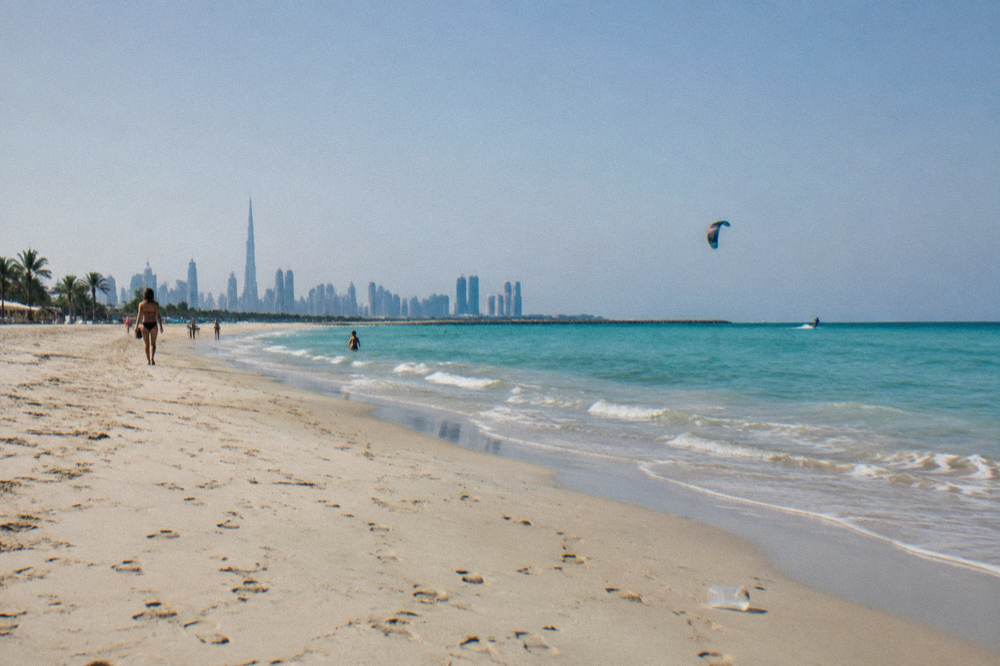 Wide sandy public beach in Dubai with calm water and a clear horizon