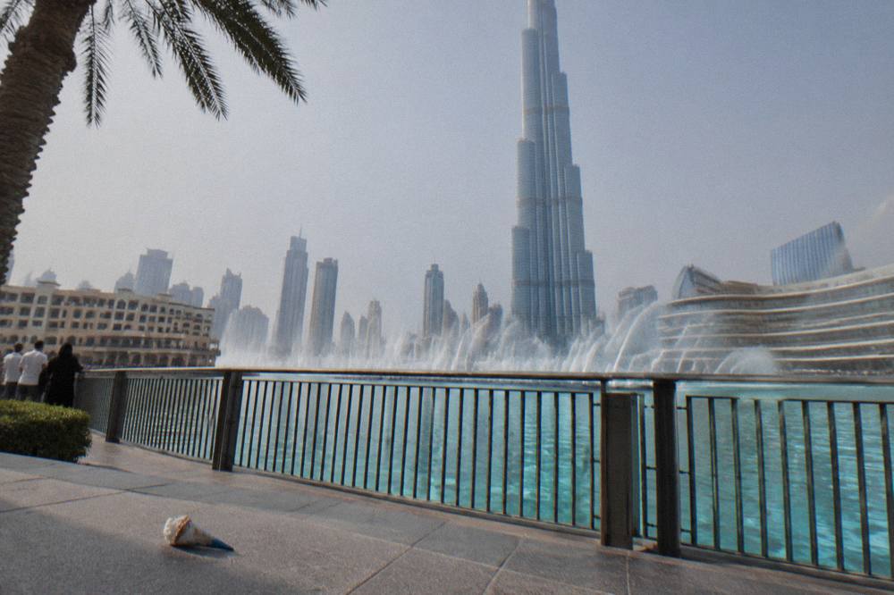 The Dubai Fountain water jets performing over Burj Lake in the afternoon