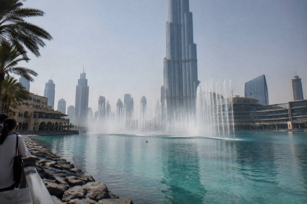 Daytime view of the Dubai Fountain jets over the lake in front of the Burj Khalifa
