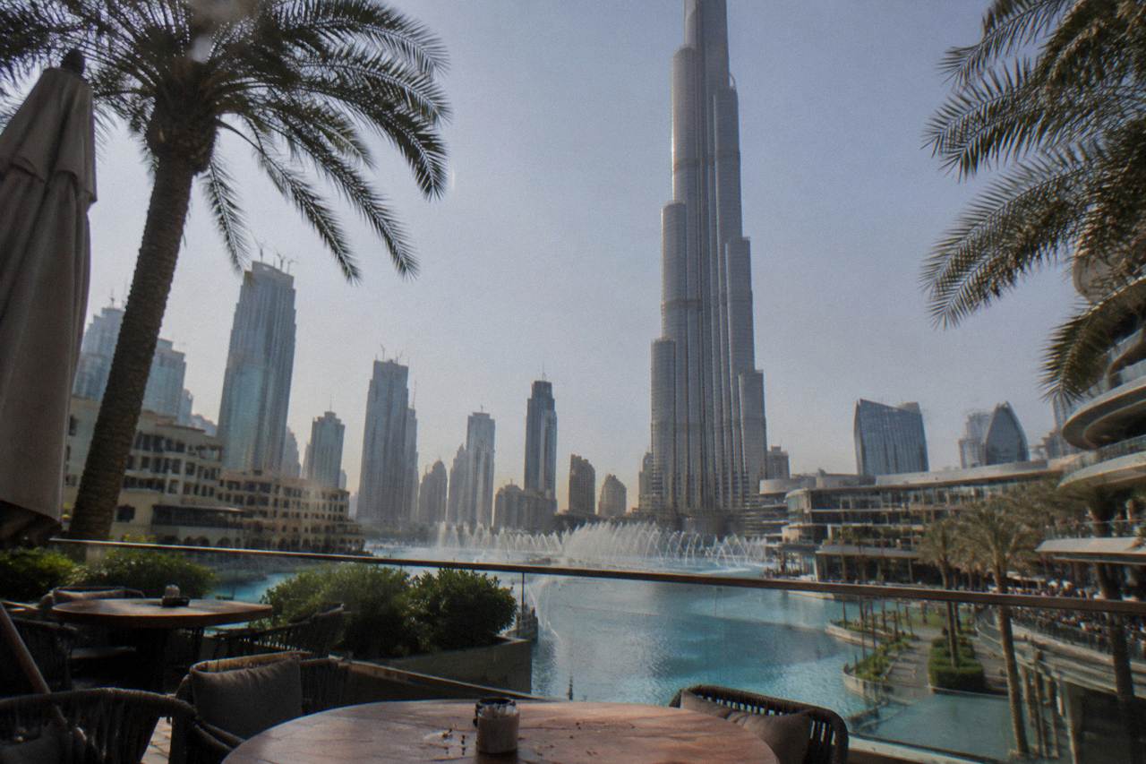 The Dubai Fountain water jets rising over Burj Lake in daylight