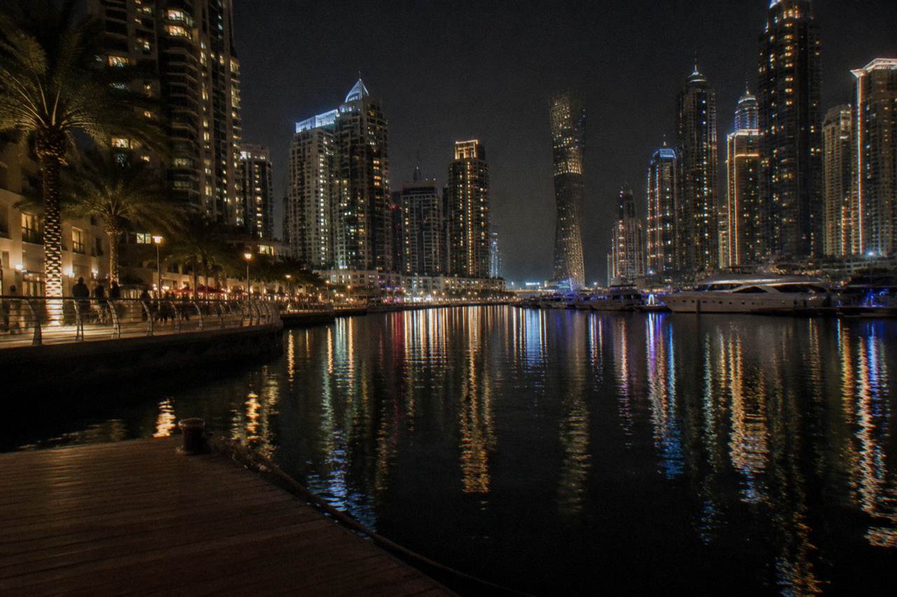 City lights reflecting on the water in Dubai after dark