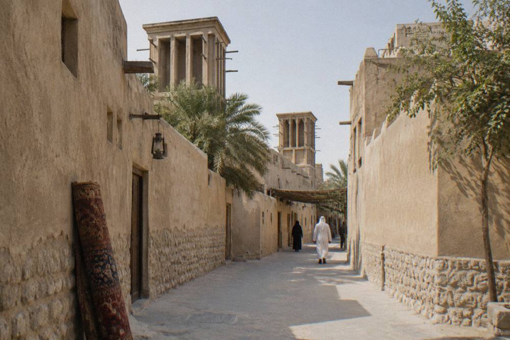 Heritage marketplace lane with wind tower buildings in old Dubai