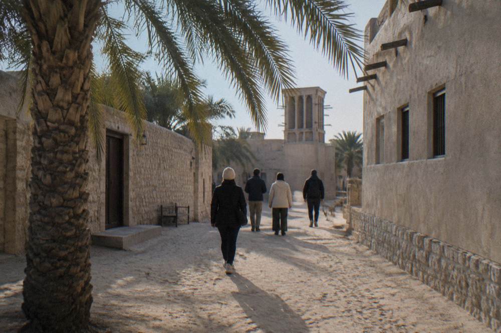 Guided walking group setting off through a heritage district street in old Dubai