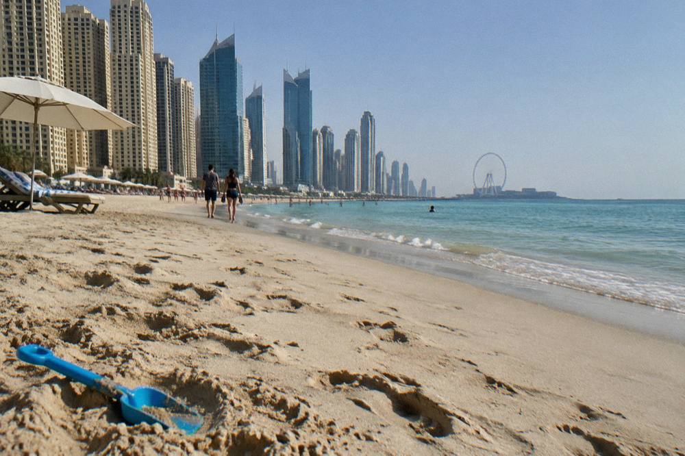 Wide sandy beach in Dubai with calm water and clear sky