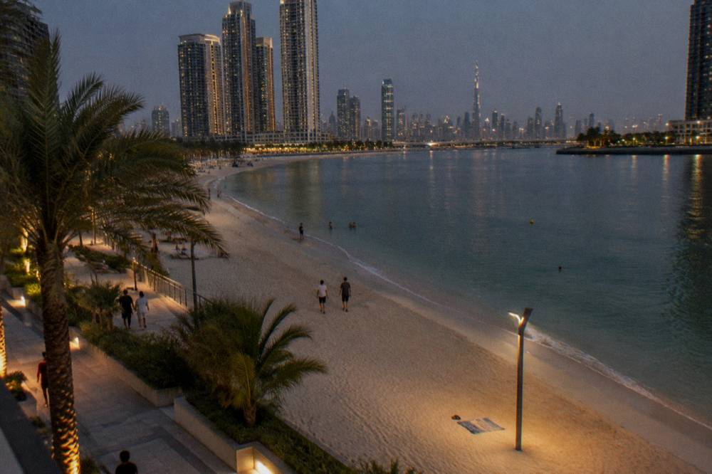 A floodlit public beach in Dubai with the water calm after sunset