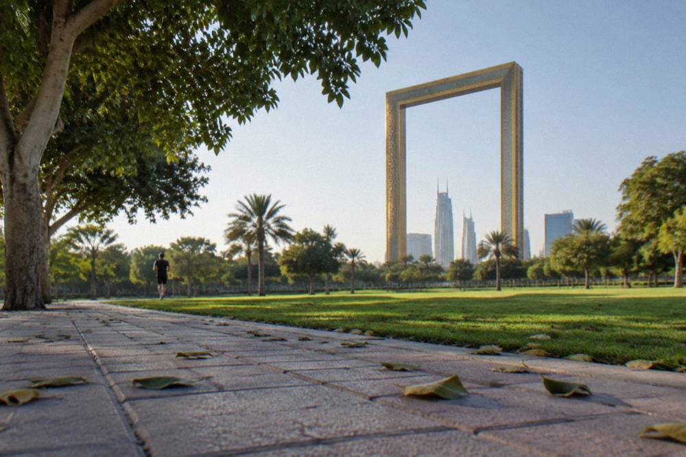 Walkways and lawns inside Zabeel Park with the Dubai Frame above