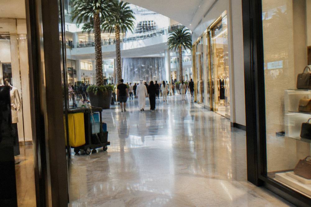 Wide corridor inside a shopping mall with shops on both sides