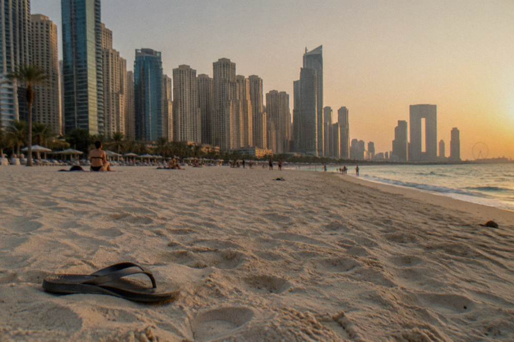 Wide sandy public beach with tall buildings behind it