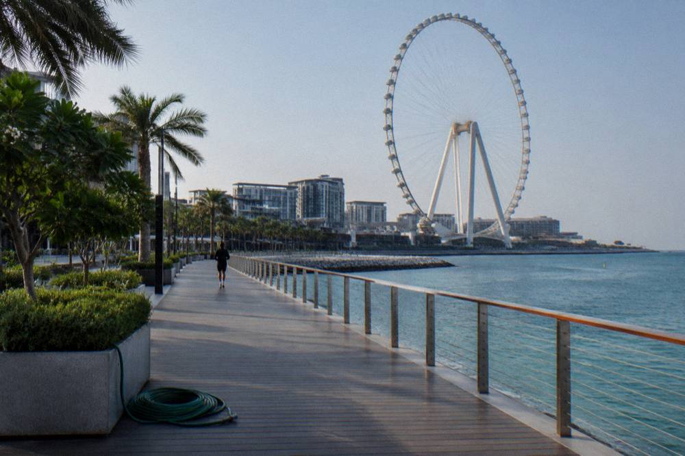 Island walkway with a large observation wheel structure in the background