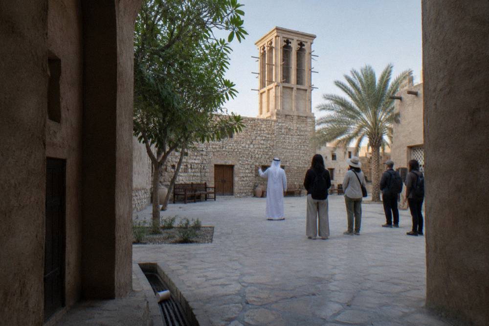 Guide speaking with a group at a heritage courtyard meeting point