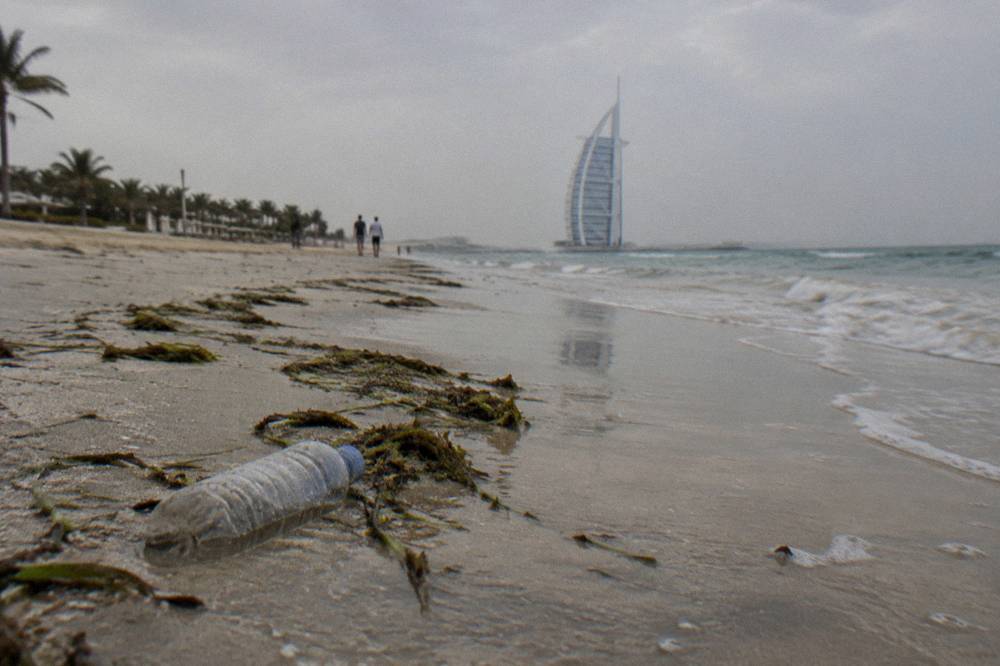 Sandy beach looking toward a tall sail-shaped hotel tower on the horizon